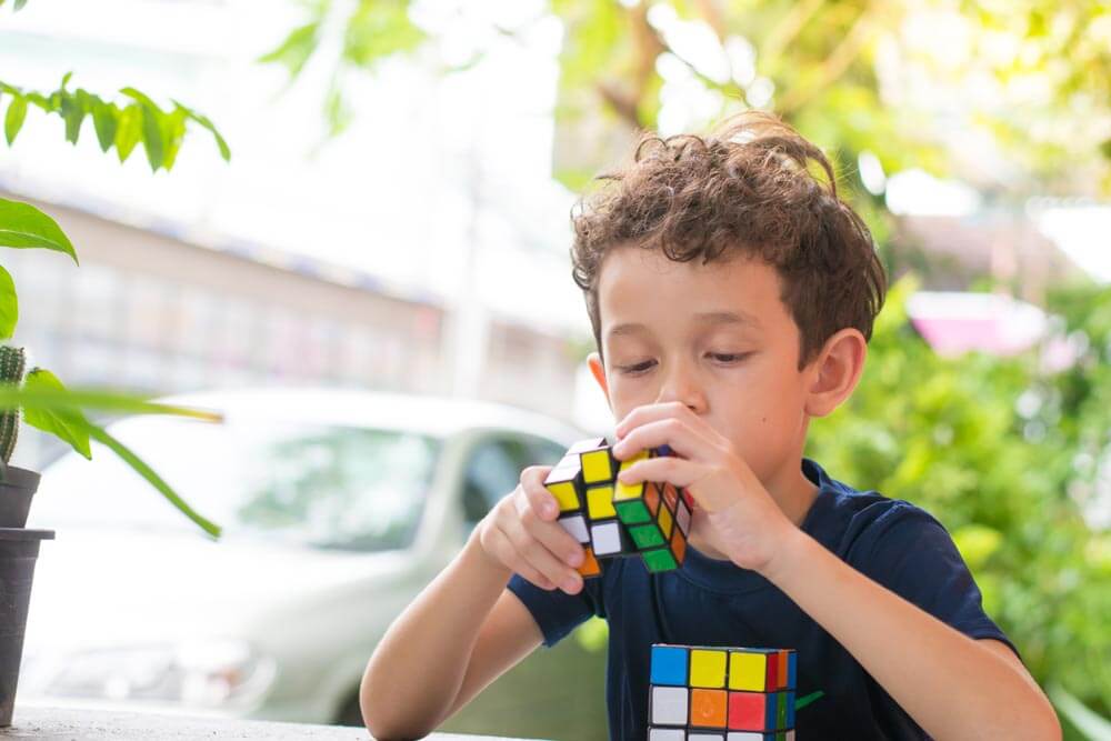 Cute boy plaiyng with the Rubik's Cube