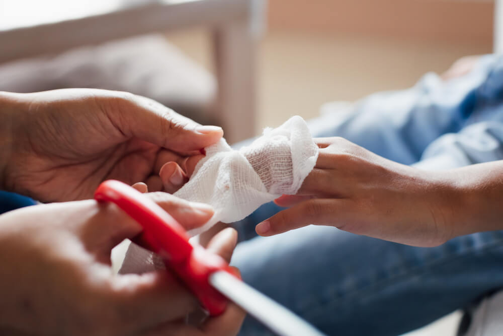 Doctor applying bandage on injured fingers